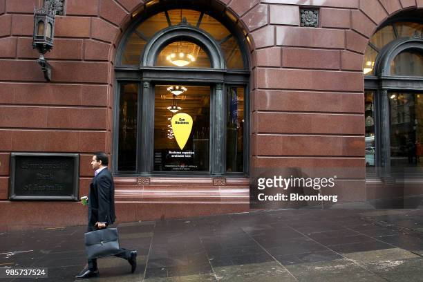 Pedestrian walks past the Commonwealth Bank of Australia branch at Martin Place in the central business district of Sydney, Australia, on Thursday,...