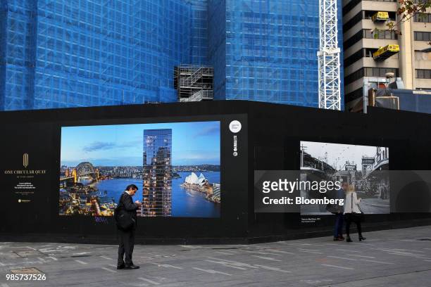 Pedestrians walk past the construction site for the One Circular Quay residential tower in the central business district of Sydney, Australia, on...