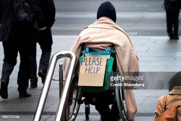 Sign reading 'Please Help' is displayed by a man in a wheelchair at Martin Place in the central business district of Sydney, Australia, on Monday,...