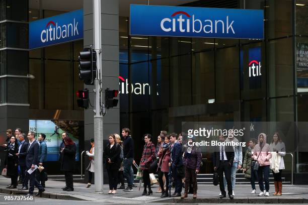 Pedestrians wait to cross a road in front of a Citigroup Inc. Citibank branch in the central business district of Sydney, Australia, on Monday, June...