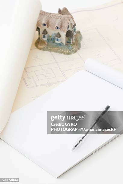 blueprint with house ornament, notepad and pen - creative rf stock-fotos und bilder