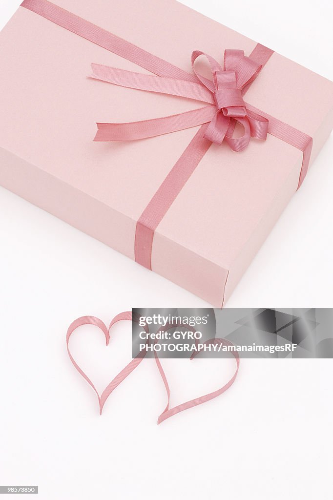 Pink present and ribbons in shape of hearts