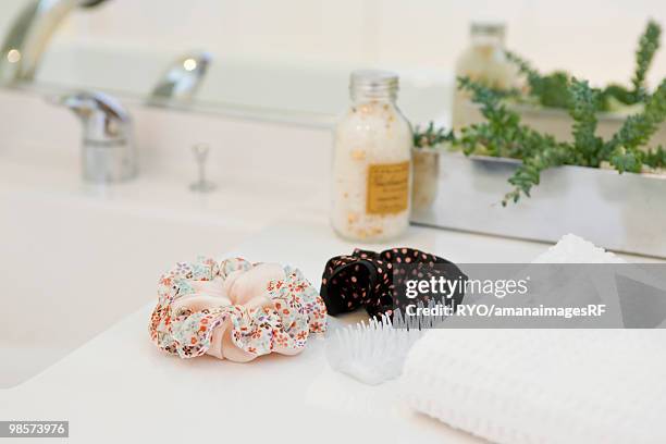 hairbrush and hair elastics in bathroom - hair bobble stock pictures, royalty-free photos & images