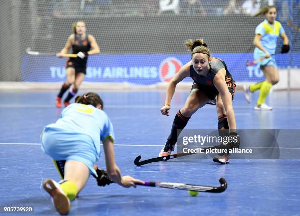 The Netherlands' Marijn Veen and the Ukraine's Yevheniya Moroz vie for the ball during the women's Indoor Hockey World Cup 2018 semifinals match...