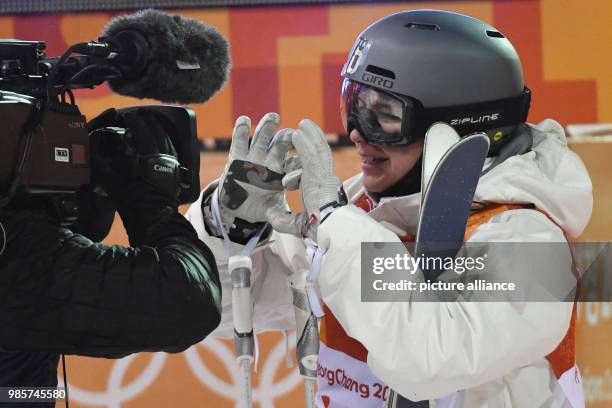Katharina Foester of Germany smiles at the finish line during the 2nd round of qualifications at the women's Olympic mogul freestlye skiing...
