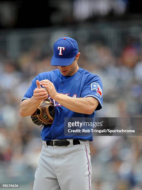Rich Harden of the Texas Rangers rubs up the ball on the mound against the New York Yankees at Yankee Stadium on April 18, 2010 in the Bronx borough...