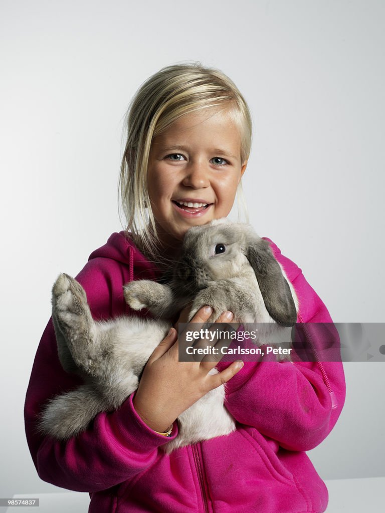 Portrait of a girl with a rabbit in her arms.