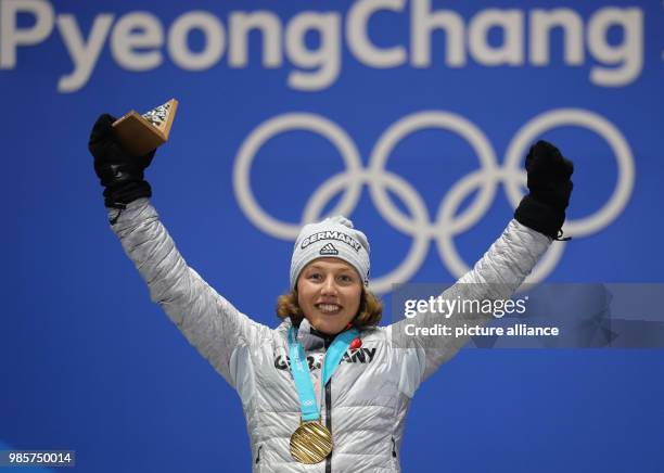 German gold medallist Laura Dahlmeier celebrates with her medal on the podium after winning the Women's Biathlon 7.5 km Sprint, during the medal...