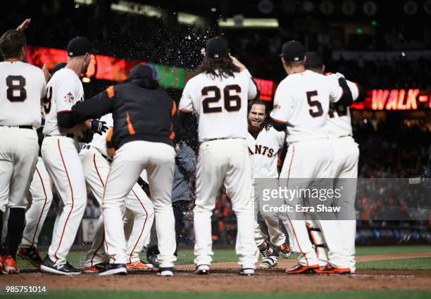 Brandon Crawford of the San Francisco Giants is congratulated by teammates after he hit a walk off home run in the ninth inning to beat the Colorado...