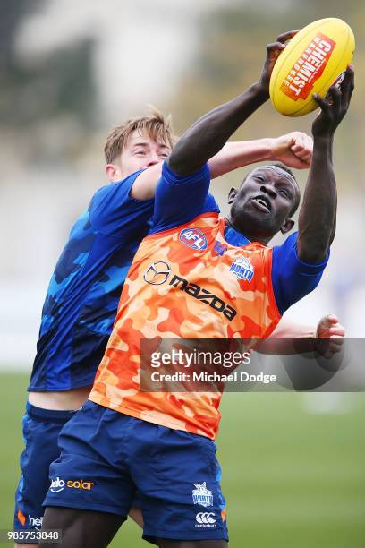 Majak Daw of the Kangaroos marks the ball against Trent Dumont of the Kangaroos during a North Melbourne Kangaroos AFL training session at Arden...