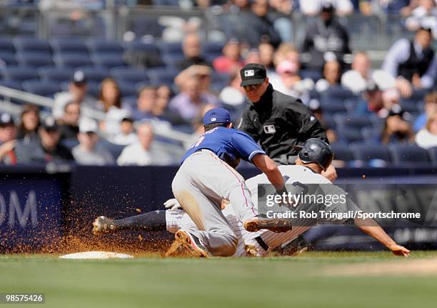 Alex Rodriguez of the New York Yankees seals third base as Michael Young of the Texas Rangers attempts to make the tag at Yankee Stadium on April 18,...