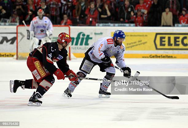 Ben Cottreau of Hannover and Thomas Kemp of Augsburg battle for the puck during the DEL play off final match between Hannover Scorpions and...