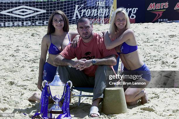 Kronenbourg promotional girls pose with ex Manchester United player Eric Cantona for photographers during the Kronenbourg Beach Soccer Cup played at...