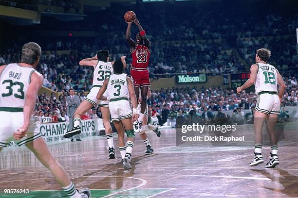 Michael Jordan of the Chicago Bulls shoots a jump shot against Kevin McHale of the Boston Celtics during a game played in 1987 at the Boston Garden...