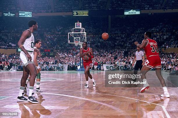 Michael Jordan of the Chicago Bulls passes to teammate Charles Oakley during a game played in 1987 against the Boston Celtics at the Boston Garden in...