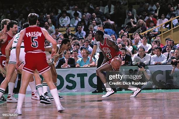 Michael Jordan of the Chicago Bulls drives the ball against Dennis Johnson of the Boston Celtics during a game played in 1987 at the Boston Garden in...