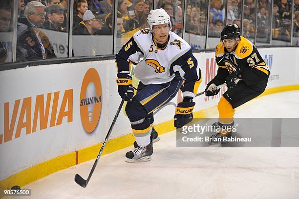 Toni Lydman of the Buffalo Sabers skates after the puck against Patrice Bergeron of the Boston Bruins in Game Three of the Eastern Conference...