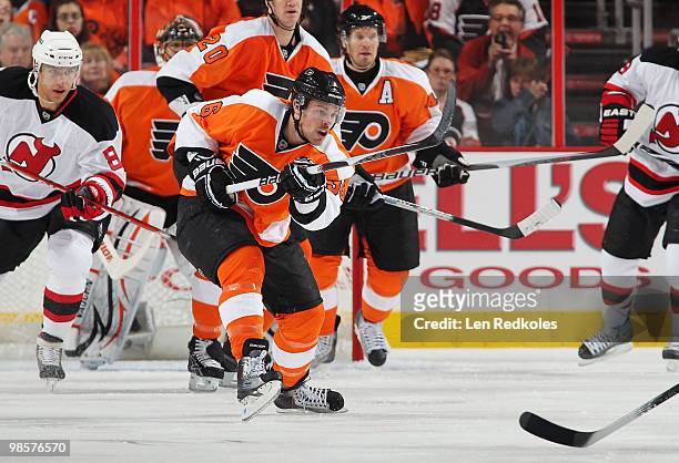 Darroll Powe of the Philadelphia Flyers clears the puck out of his defensive zone against Dainius Zubrus of the New Jersey Devils in Game Three of...