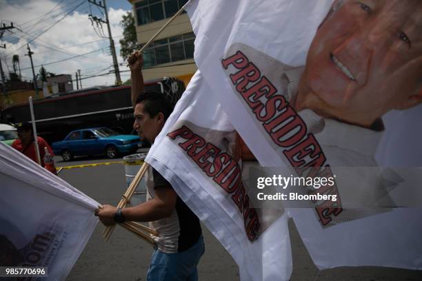 Vendor carries a flag featuring a portrait of Andres Manuel Lopez Obrador, presidential candidate of the National Regeneration Movement Party , ahead...