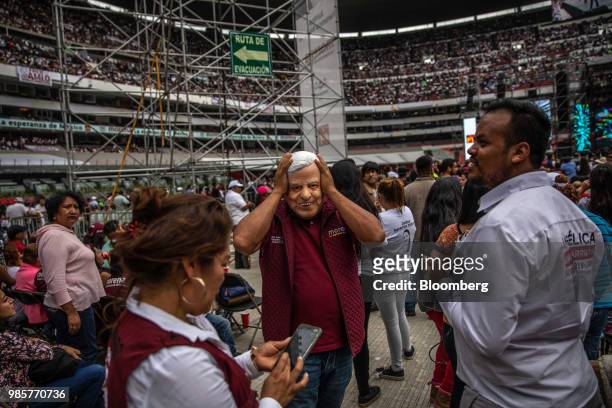 Supporter wears a mask in the likeness of Andres Manuel Lopez Obrador, presidential candidate of the National Regeneration Movement Party , during...