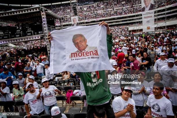 Supporter holds a flag featuring a portrait of Andres Manuel Lopez Obrador, presidential candidate of the National Regeneration Movement Party ,...