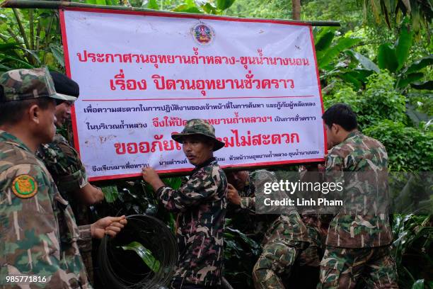 Thai officials install a sign telling that the entrance to Tham Luang Nang Non cave is closed on June 28, 2018 in Chiang Rai, Thailand. Rescuers...