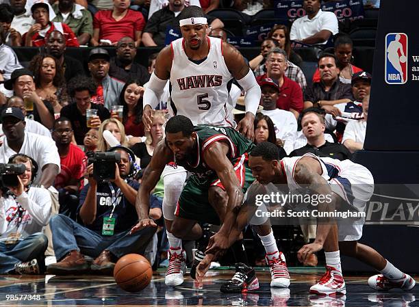 John Salmons of the Milwaukee Bucks and Jeff Teague of the Atlanta Hawks dives for a loose ball in Game One of the Eastern Conference Quarterfinals...