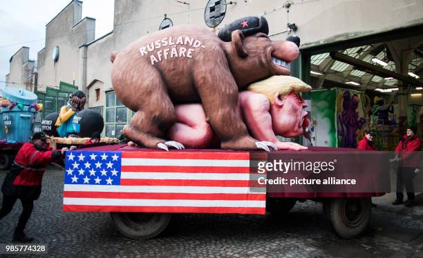 Helpers prepare a political caricature float featuring a "Russian bear" on top of the figure of "Donald Trump, the 45th president of the United...