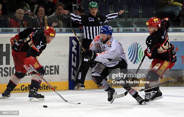 Ben Cottreau of Hannover and Darin Olver of Augsburg battle for the puck during the DEL play off final match between Hannover Scorpions and...