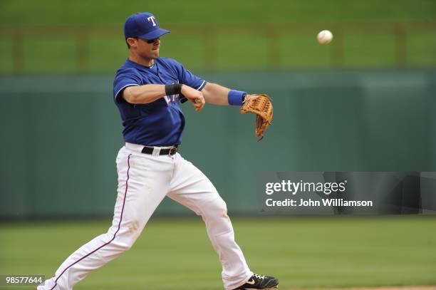 Third baseman Michael Young of the Texas Rangers fields his position as he throws to first base after catching a ground ball during the game against...