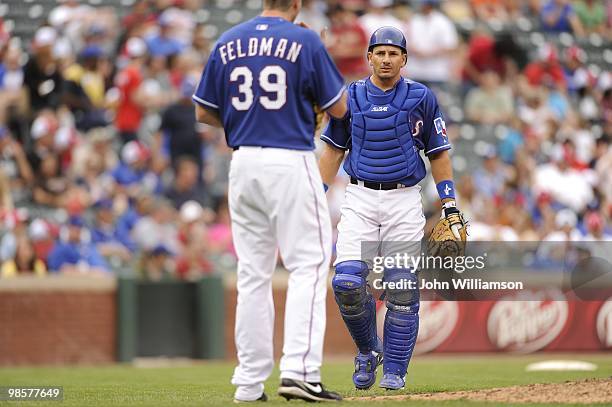 Catcher Matt Treanor of the Texas Rangers walks to the pitcher's mound and talks to pitcher Scott Feldman during the game against the Seattle...