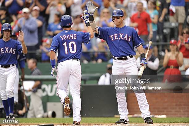 Josh Hamilton of the Texas Rangers congratulates Michael Young on hitting a home run during the game against the Seattle Mariners at Rangers Ballpark...