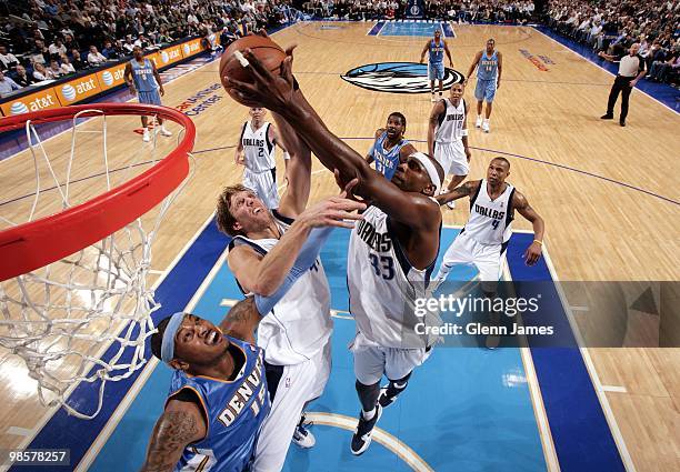 Brendan Haywood of the Dallas Mavericks goes up for the rebound against teammate Dirk Nowitzki and Carmelo Anthony of the Denver Nuggets during the...