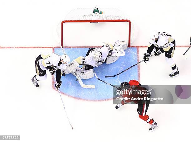 Matt Cullen of the Ottawa Senators is stopped by Marc-Andre Fleury, Mark Eaton and Craig Adams of the Pittsburgh Penguins on a shot from just outside...