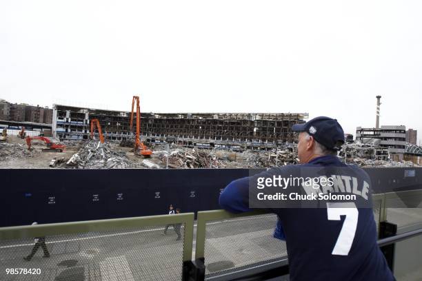 View of the remains of old Yankee Stadium during demolition before New York Yankees vs Los Angeles Angels of Anaheim game. Yankee fan wearing Mickey...