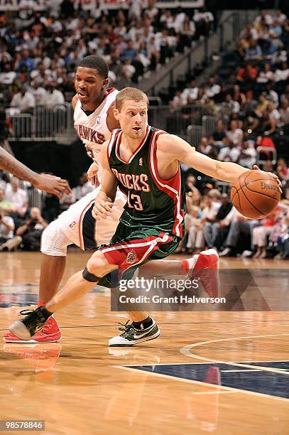 Luke Ridnour of the Milwaukee Bucks dribbles against Joe Johnson of the Atlanta Hawks in Game One of the Eastern Conference Quarterfinals during the...