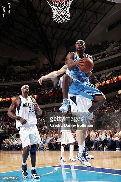 Ty Lawson of the Denver Nuggets goes to the basket against Brendan Haywood and Dirk Nowitzki of the Dallas Mavericks during the game at American...