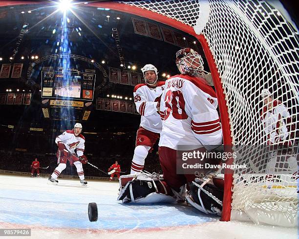 Ilya Bryzgalov of the Phoenix Coyotes and teammate Ed Jovanovski look back at the puck during Game Four of the Eastern Conference Quarterfinals of...