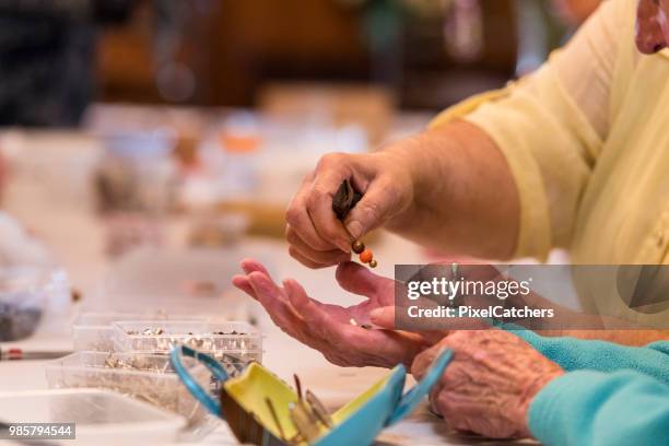 cerca de las manos del senior femenino con granos - hacer cuentas fotografías e imágenes de stock