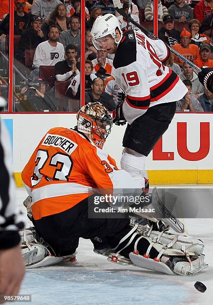 Brian Boucher of the Philadelphia Flyers makes a first period save under pressure from Travis Zajac of the New Jersey Devils in Game Four of the...