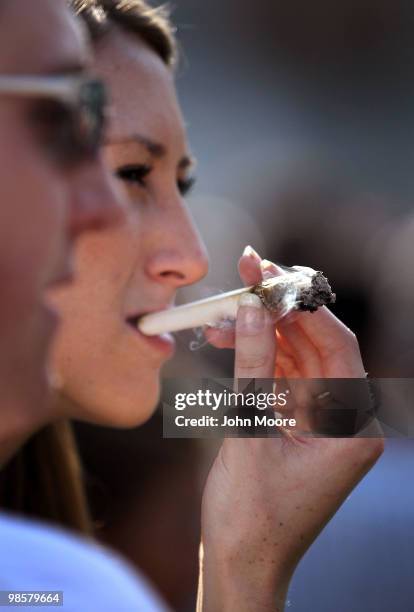 Woman smokes a joint at a pro-marijuana "4/20" celebration in front of the state capitol building April 20, 2010 in Denver, Colorado. April 20th has...