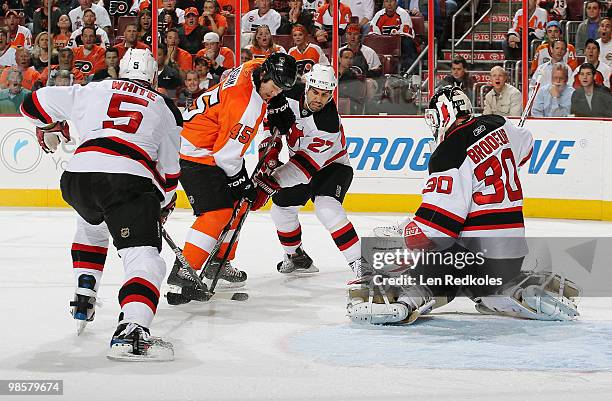 Colin White, Mike Mottau and Martin Brodeur of the New Jersey Devils defend against the attack of Arron Asham of the Philadelphia Flyers in Game Four...