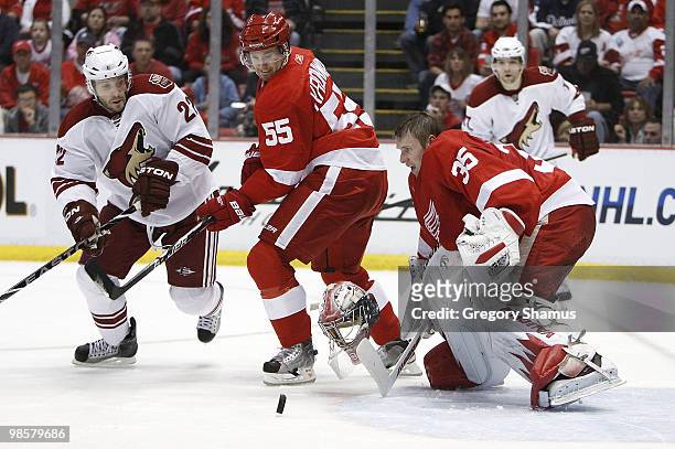 Jimmy Howard of the Detroit Red Wings makes a save without his goalie mask behind teammate Niklas Kronwall and Lee Stempniak of the Phoenix Coyotes...