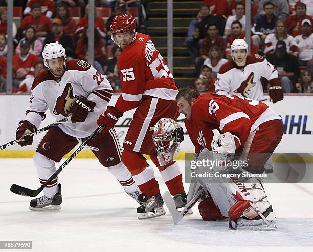 Jimmy Howard of the Detroit Red Wings loses his mask making a save behind teammate Niklas Kronwall and Lee Stempniak of the Phoenix Coyotes during...