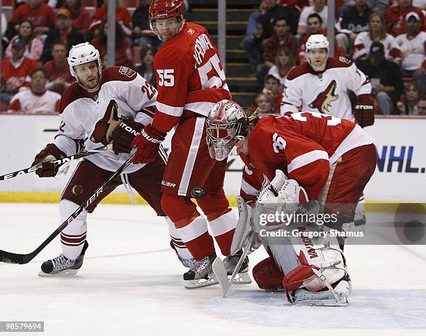 Jimmy Howard of the Detroit Red Wings loses his mask making a save behind teammate Niklas Kronwall and Lee Stempniak of the Phoenix Coyotes during...