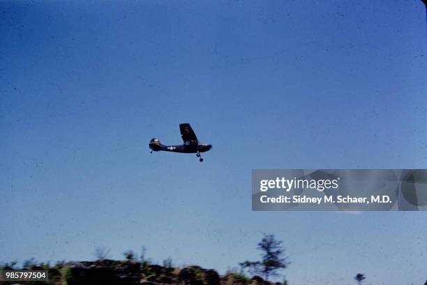 View of a Cessna L-19 Bird Dog observation plane as it flies overhead, South Korea, May 1952.