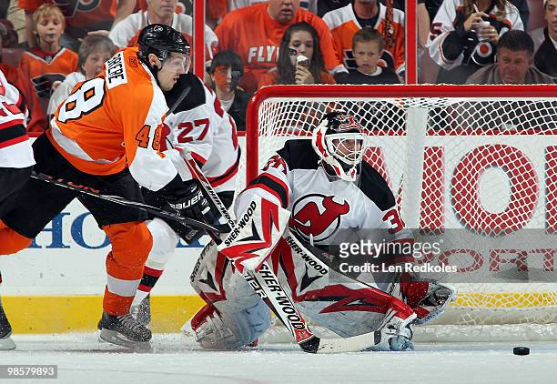 Martin Brodeur of the New Jersey Devils makes a save as Danny Briere of the Philadelphia Flyers reaches for the rebound in Game Four of the Eastern...