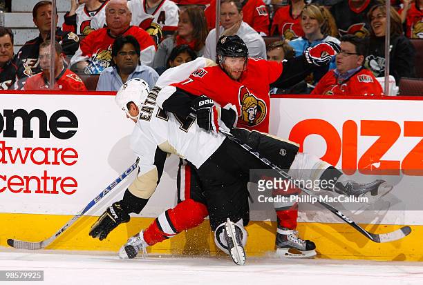Mark Eaton of the Pittsburgh Penguins throws a bodycheck on Matt Cullen of the Ottawa Senators along the far boards during Game 4 of the Eastern...