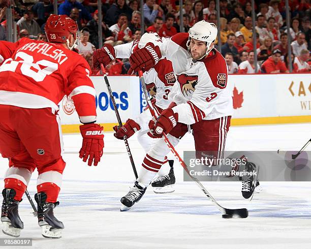 Keith Yandle of the Phoenix Coyotes controls the puck as he tries to skate around the defense of Brian Rafalski of the Detroit Red Wings during Game...