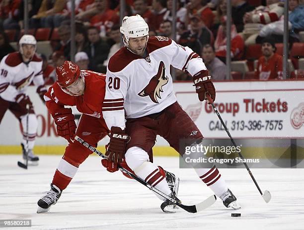 Robert Lang of the Phoenix Coyotes tries to control the puck in front Darren Helm of the Detroit Red Wings during Game Four of the Western Conference...